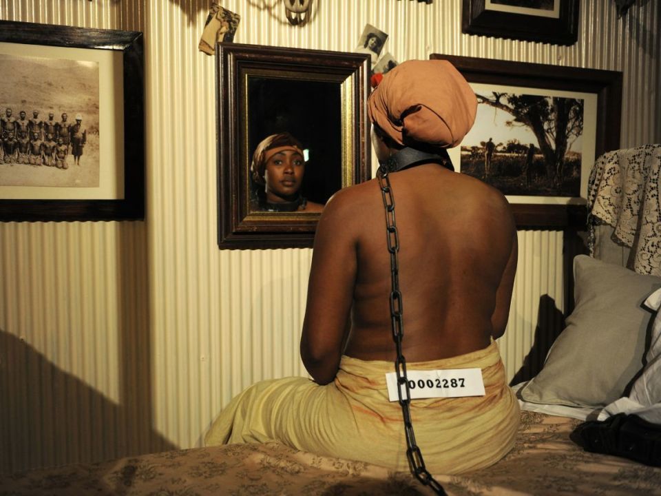 A Place in the Sun, from Brett Bailey’s “Exhibit B”. This installation was based on an account of a French colonial officer who kept black women chained to his bed, exchanging food for sexual services.